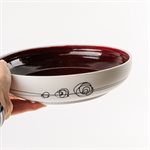 Large porcelain serving bowl with red interior