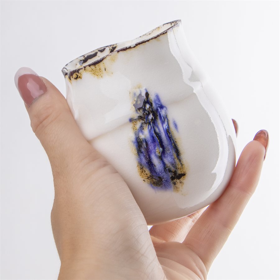 Petit verrre en porcelaine, contour oxydé et ornement bleu Petit verrre en porcelaine, contour oxydé et ornement bleu