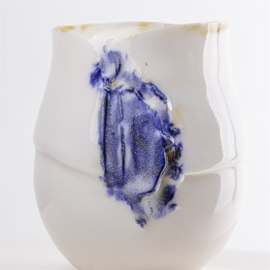 Petit verrre en porcelaine, contour oxydé et ornement bleu Petit verrre en porcelaine, contour oxydé et ornement bleu